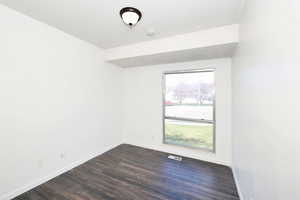 Spare room with dark wood-type flooring and a textured ceiling