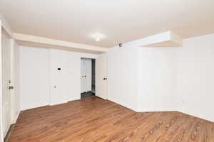 Finished basement featuring wood finished floors and baseboards