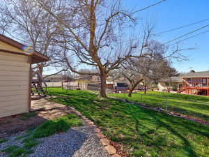 Fenced backyard featuring a wooden deck and a residential view