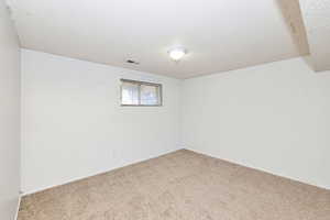 Spare room featuring a textured ceiling and carpet