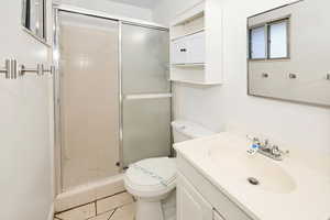 Bathroom featuring vanity, a shower stall, and light tile patterned floors