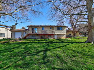 Back of house featuring a wooden deck and a garage