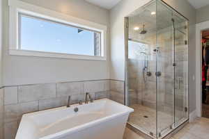 Bathroom featuring a walk in closet, a freestanding bath, a stall STEAM shower, and recessed lighting