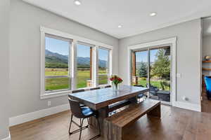 Dining area with a mountain view, light wood finished floors, plenty of natural light, and recessed lighting