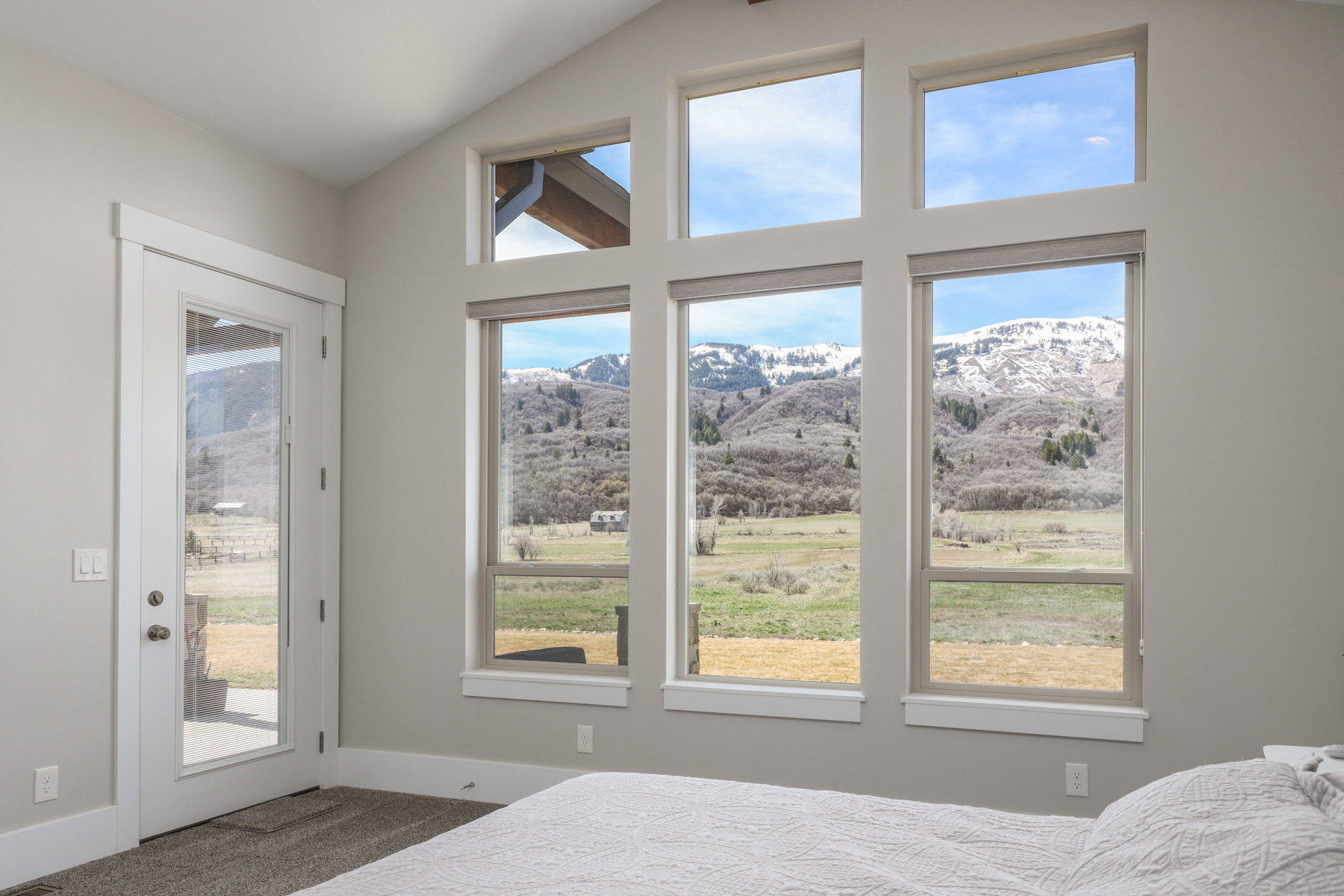 Bedroom with a mountain view, access to exterior, dark carpet, and lofted ceiling