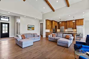 Living area featuring light wood flooring, recessed lighting, and vaulted ceiling.
