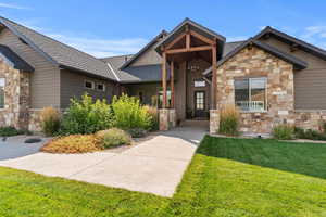 Craftsman-style house featuring stone siding, timber beams and presidential shingles.
