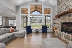 Living area with a stone fireplace, hardwood / wood-style flooring, recessed lighting, and a mountain view