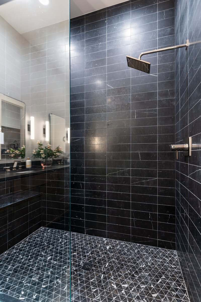 Bathroom featuring a shower stall and a sink