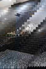 Bathroom featuring a shower stall and a sink