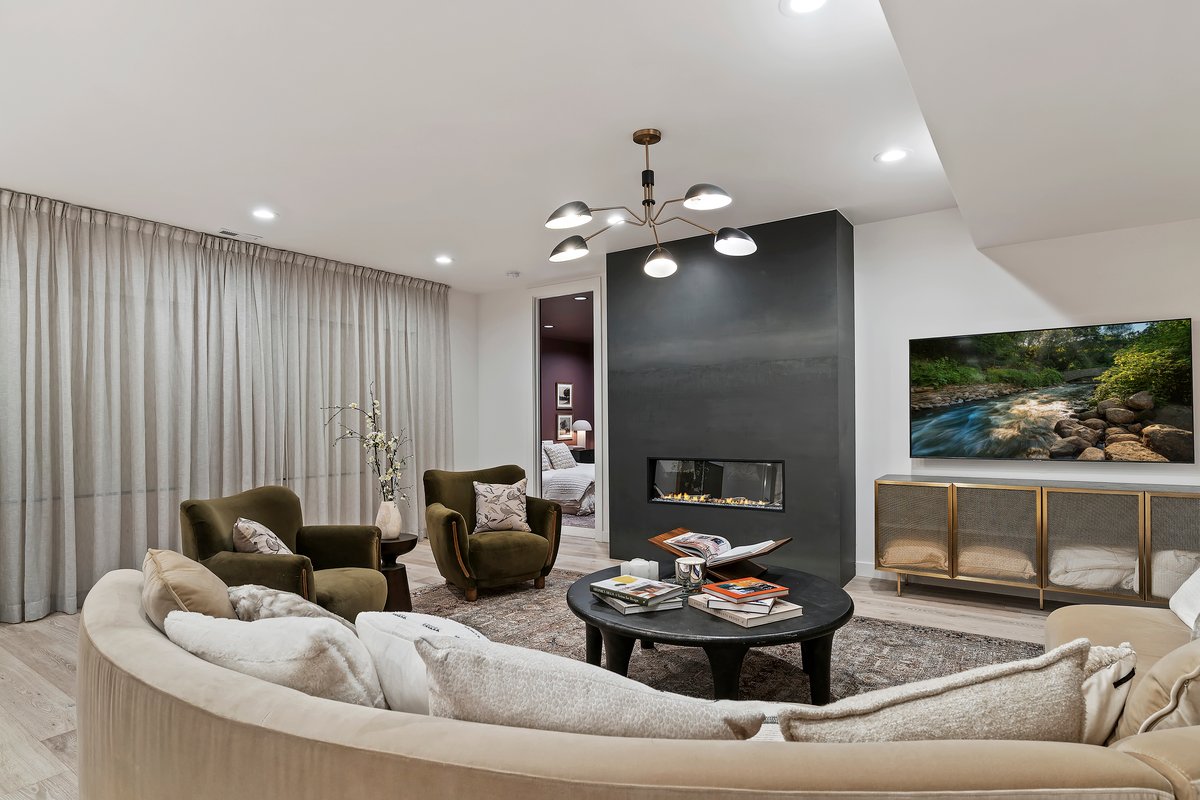 Living area with light wood-type flooring, suspended lighting, and a fireplace