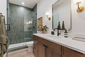 Bathroom with vanity, a stall shower, light wood-type flooring, and recessed lighting