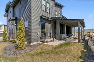 Rear view of property featuring a patio area and a yard