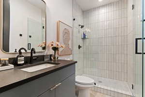 Bathroom featuring vanity, a stall shower, and light wood-style flooring