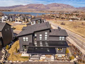 Back of property with a residential view, a mountain view, a patio, and a metal roof