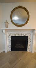 Detailed view of a tiled fireplace and wood finished floors