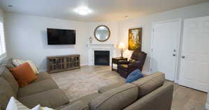 Living area with light wood finished floors and a tiled fireplace
