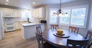 Dining space with light wood-type flooring and a chandelier