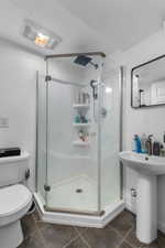 Full bathroom with toilet and a stall shower