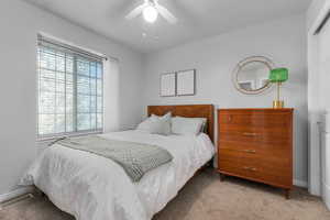Carpeted bedroom with a ceiling fan and a closet