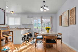 Dining space featuring light wood-style floors and suspended lighting