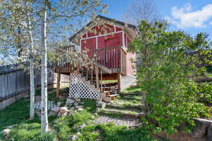 Back of house with a wooden deck and stairs