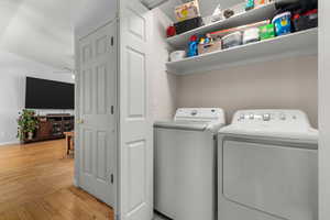 Laundry area featuring light wood-type flooring and independent washer and dryer