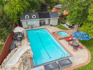 View of pool with outdoor lounge area, patio surround, and an in-ground hot tub
