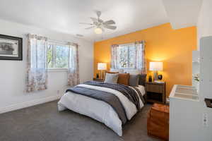 Carpeted bedroom featuring multiple windows and a ceiling fan