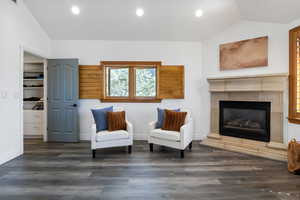 Sitting room with vaulted ceiling, a glass covered fireplace, dark wood-type flooring, and recessed lighting