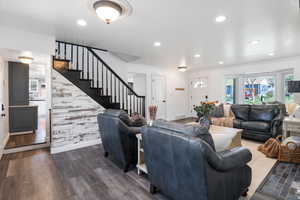 Living area featuring healthy amount of natural light, ornamental molding, dark wood-style flooring, and recessed lighting