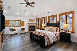 Bedroom with lofted ceiling, dark wood-style flooring, a fireplace, ceiling fan, and recessed lighting