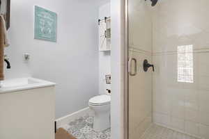 Bathroom featuring a shower stall, vanity, and light tile patterned floors