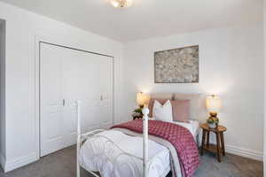 Bedroom featuring a closet and dark colored carpet