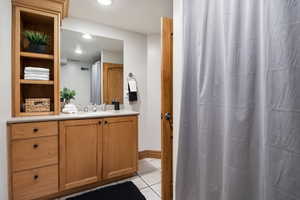 Bathroom with vanity, a shower with curtain, light tile patterned floors, and recessed lighting