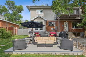 Back of house featuring an outdoor living space, a wooden deck, a patio area, and stucco siding