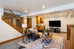 Living area with light colored carpet and recessed lighting