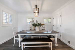 Dining area featuring dark wood finished floors and ornamental molding