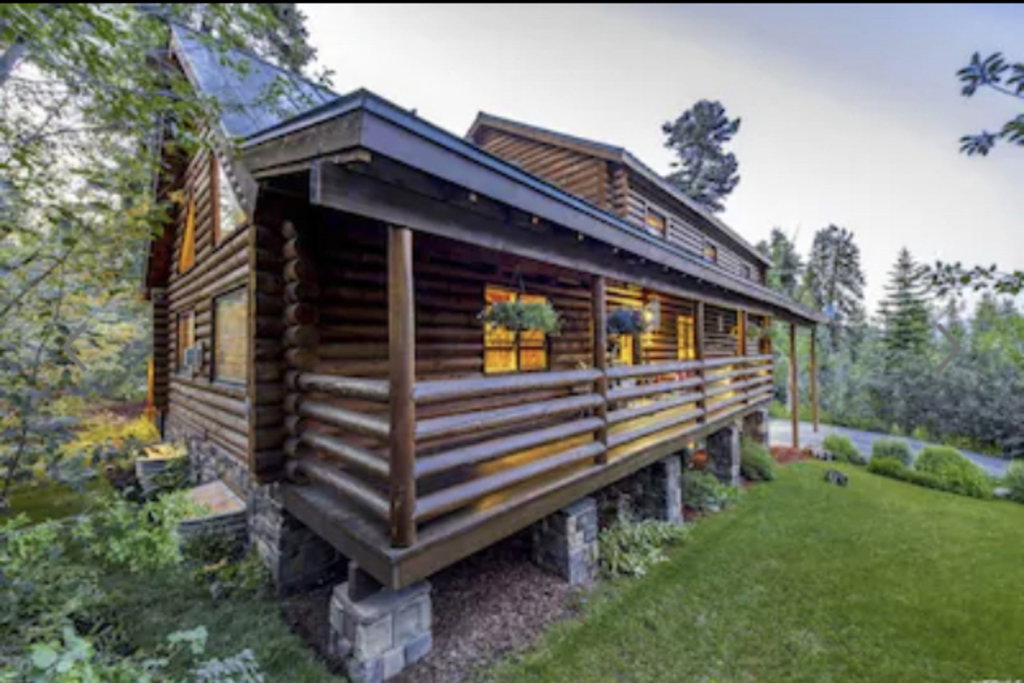 View of side of home with log exterior and a yard