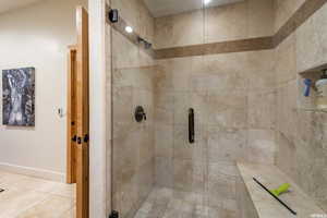 Full bathroom featuring a shower stall and tile patterned flooring