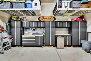 View of garage work area and hanging shelves