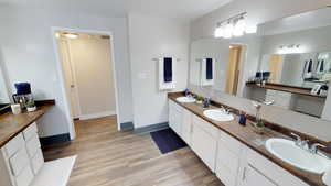 Bathroom featuring double vanity and light wood finished floors