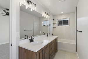 Full bathroom featuring double vanity, ceiling fan, and bathing tub / shower combination