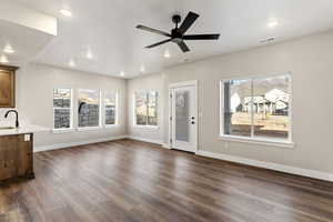Unfurnished living room featuring dark wood-type flooring, a ceiling fan, and recessed lighting