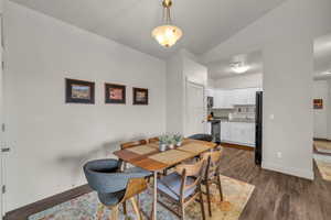 Dining space featuring vaulted ceiling and dark wood finished floors