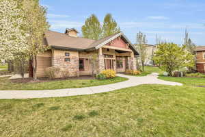 Craftsman house with stone siding, a front yard, and a shingled roof