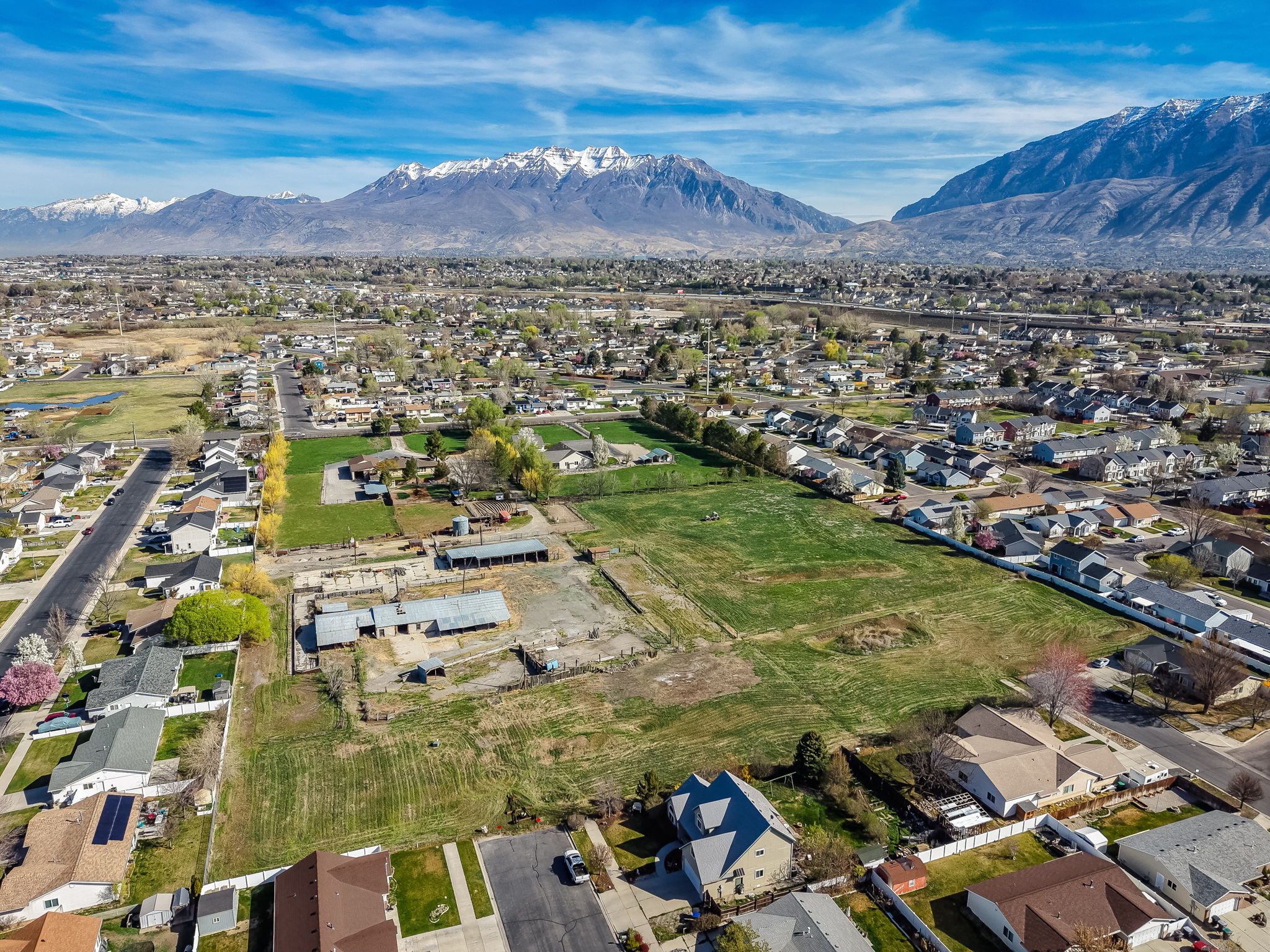 Aerial view of property and surrounding area featuring nearby suburban area