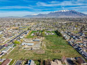 Aerial view of property and surrounding area with nearby suburban area and mountains