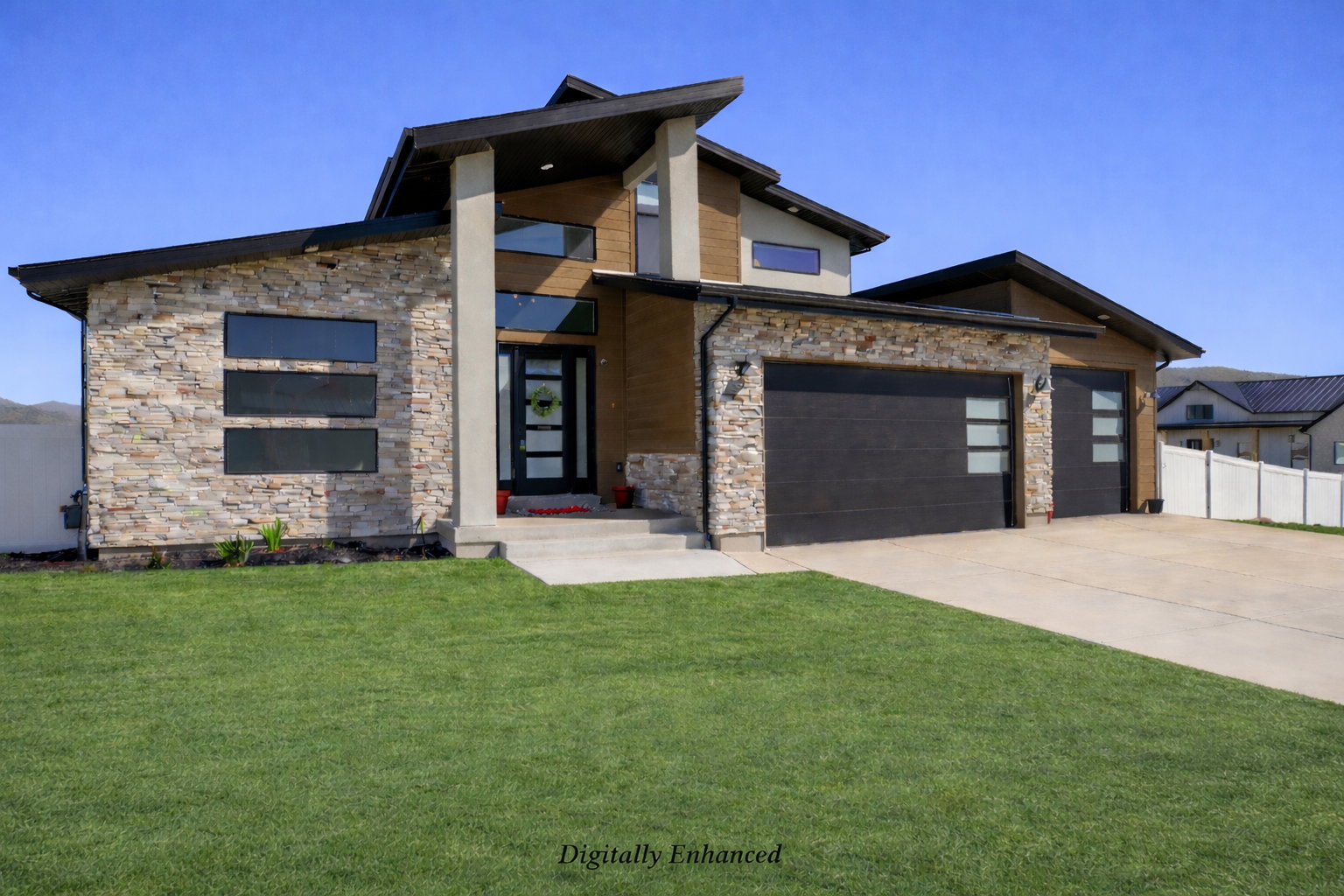Contemporary house with stone siding, a garage, and concrete driveway