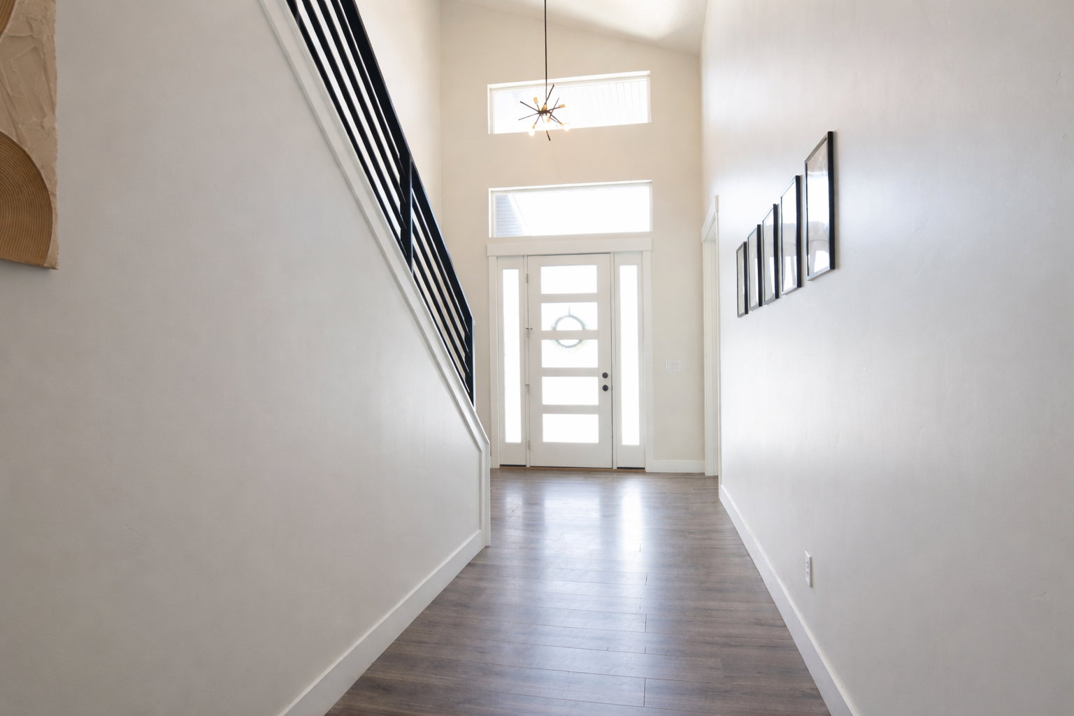 Foyer entrance featuring a high ceiling and dark wood-style flooring